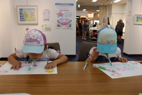 体験コーナーで、口で絵を描く子供たち